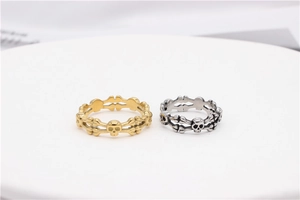 Detail of silver and gold skull crossbone rings on a white display pedestal