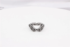 Gothic vintage silver skeleton hands forming a heart shape on a minimalist ring