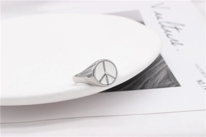 Macro detail of silver titanium peace sign ring on minimalist lifestyle background