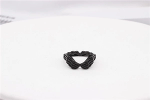 Detail of gothic black skull hands forming a heart shape on a vintage steel ring