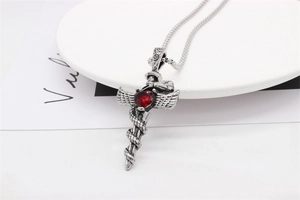 Detail of gothic sword pendant with red heart gemstone and winged snake motif