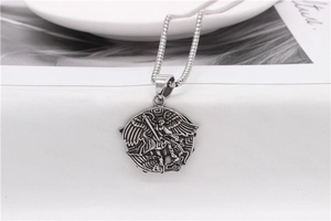 Detailed close-up of retro silver Archangel Saint Michael relief pendant on a box chain