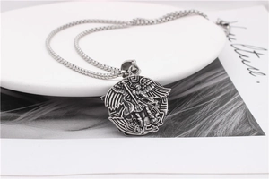 Detailed close-up of Archangel Michael steel pendant on a box chain with vintage finish