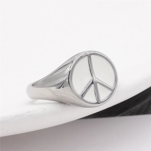 Minimalist silver peace sign signet ring with white enamel finish on a stone base