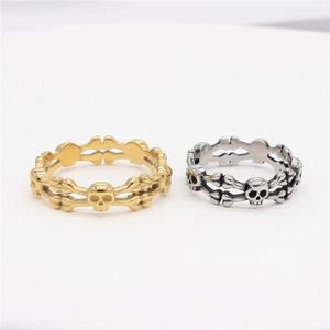 Retro punk skull ring in gold and antique silver featuring a crossbone skeleton design