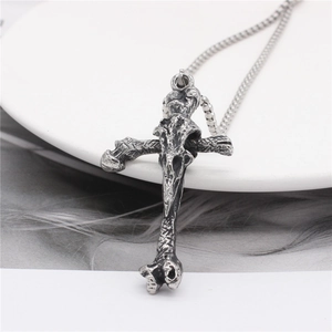 Vintage Viking cross bone pendant in gothic silver steel style on a white dish