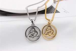 Detailed view of silver and gold Celtic knot necklaces on minimalist white background