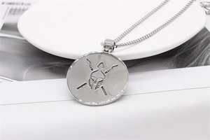 Macro detail of men's stainless steel spartan helmet and spears engraved round pendant