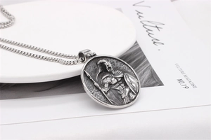 Macro shot of retro Spartan warrior embossed pendant on a stainless steel box chain