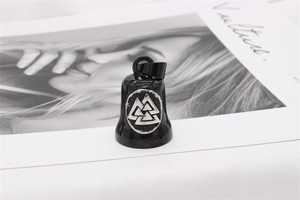 Detail of black Viking bell pendant with Valknut symbol over an artistic background