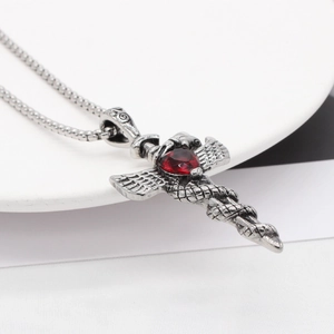 Vintage cross necklace with wings, serpent, and red heart gemstone in silver finish