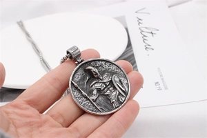 Macro detail of vintage silver Spartan warrior relief pendant on a steel box chain