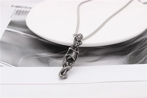 Macro shot of a vintage gothic snake and skull pendant with a stainless steel box chain