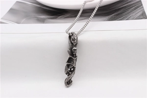 Detail of gothic snake and skull pendant with vintage finish on stainless steel chain