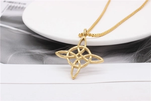 Detail of a golden Celtic knot pendant on a bead chain necklace over white ceramic