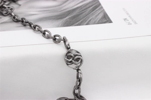 Detailed close-up of retro silver stainless steel snake pendant on a chunky chain