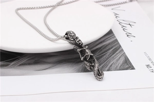Detailed view of gothic skull and snake skeleton pendant on a stainless steel chain