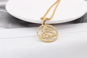 Macro shot of gold Celtic Trinity Knot pendant necklace on a clean white display stand