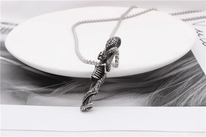 Close-up of gothic stainless steel necklace featuring a detailed snake and skull pendant