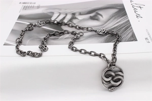 Detail of vintage silver double snake pendant with fine scale texture on thick chain