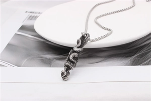 Detailed close-up of retro silver snake pendant with textured scales on vintage box chain