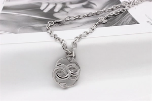 Detail of gothic silver snake pendant with scale texture and chunky rolo chain necklace