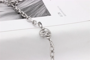 Macro shot of silver cobra pendant with detailed scales on a thick metal link chain