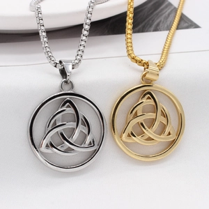 Vintage Viking Trinity Knot pendants in gold and silver steel on a textured background