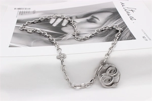 Macro shot of vintage silver snake link chain necklace on a minimalist magazine backdrop