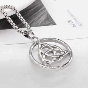 Vintage silver Celtic Triquetra pendant with box chain on a white textured background