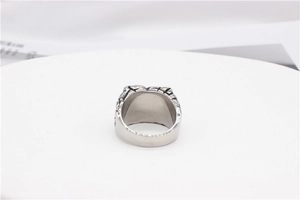 Detailed close-up of retro silver stainless steel men's ring with etched devil eye pattern