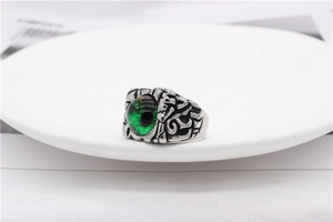 Detailed relief carving on a vintage silver ring featuring a green evil eye stone