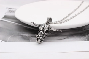 Macro shot of retro bull skull pendant with weathered titanium steel finish and bead chain