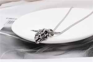 Macro shot of antique silver bull skull pendant with detailed punk style engravings