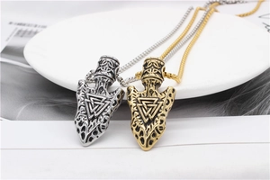 Detailed view of Viking arrow pendants in gold and silver with Valknut rune symbols
