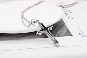 Detailed view of silver cross pendant with black stripes on stylish magazine background