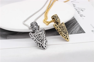 Detailed close-up of Viking Valknut arrow pendants in silver and gold finishes