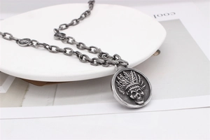 Gros plan d'un collier en argent vintage avec pendentif crâne indien sur une chaîne épaisse