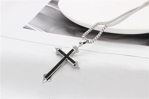 Detail of gothic silver cross pendant with black inlay and square box chain necklace
