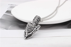 Macro detail of Nordic Viking Valknut arrow pendant in antique silver finish on a chain