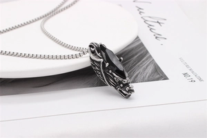 Detailed close-up of retro dragon head pendant with black marquise gemstone and chain