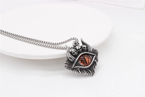 Vue macro d'un pendentif œil de dragon punk avec trois crânes sur chaîne en acier vintage