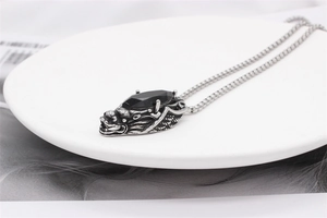 Detail of vintage dragon pendant with black gemstone and intricate scale texture