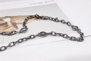 Détail d'une chaîne en argent vintage avec pendentifs pièces de monnaie chef indien