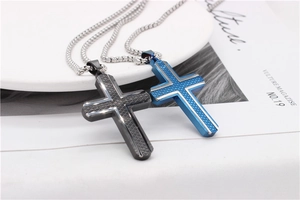 Detailed macro view of cross pendants with textured diamond patterns on a ceramic plate