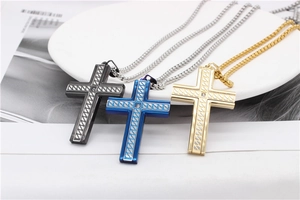 Three-color cross necklaces in black, blue and gold with woven texture on a plate