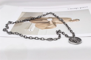 Détail de la chaîne argentée avec pendentif crâne à plumes au style indien vintage