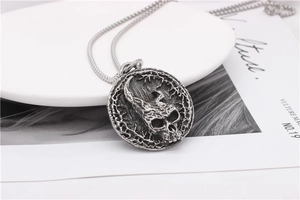 Close-up of retro stainless steel pendant with detailed gothic horned skull engraving