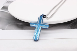 Detail of blue electroplated cross pendant with fish scale texture on silver chain