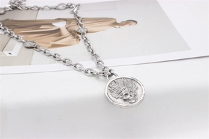 Détail du pendentif tête de mort indien argenté avec gravures en relief vintage
